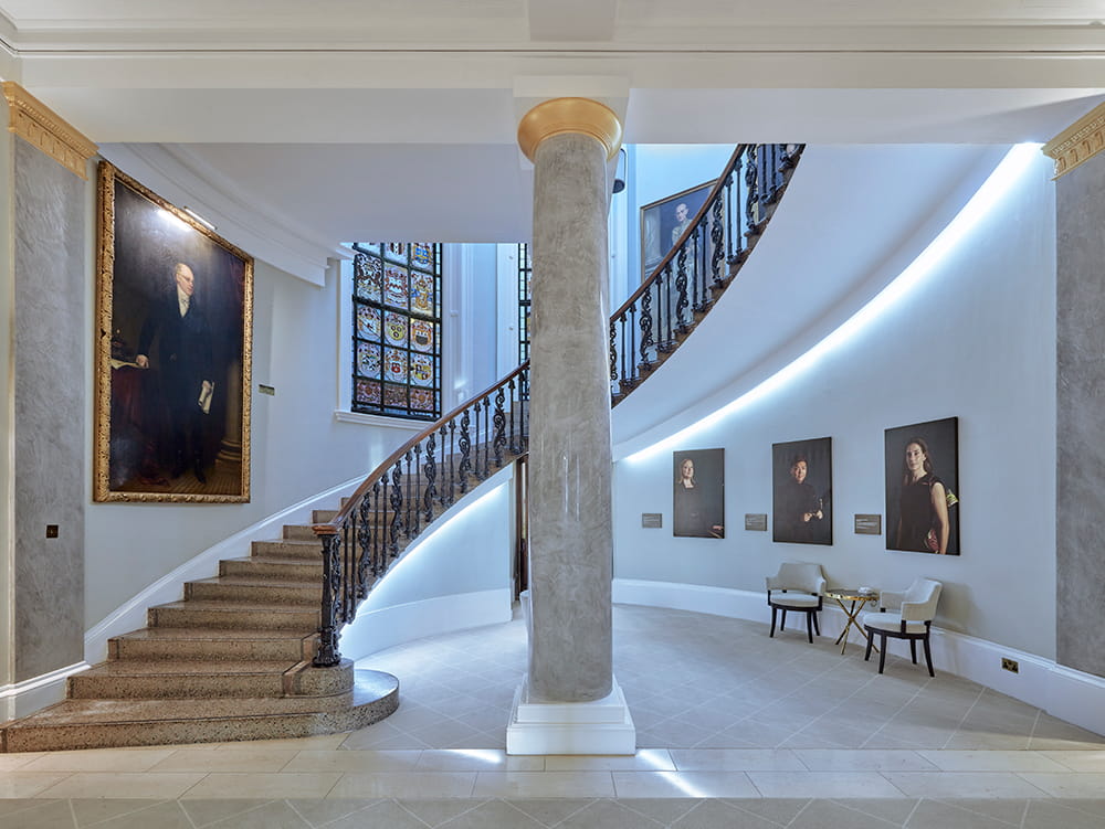 Ornate curved staircase leading to Law Society Library in 113 Chancery Lane: stained glass window and gold-framed portraits with central marble pillar 