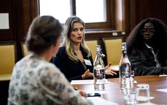 A table of in-house solicitors in deep conversation at a forum.